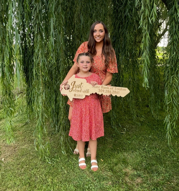 Mother and Daughter with the symbolic key to their new home